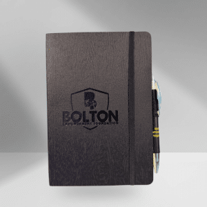 Capture your thoughts, notes, and ideas with this sleek medium-sized journal. The Bolton Empowerment Foundation logo is embossed on the cover, and a matching pen is included so you’re always ready to write. Your purchase makes an impact. Every item from our store helps fund mentorship, education, and wellness programs for youth in foster care and individuals facing breast cancer.